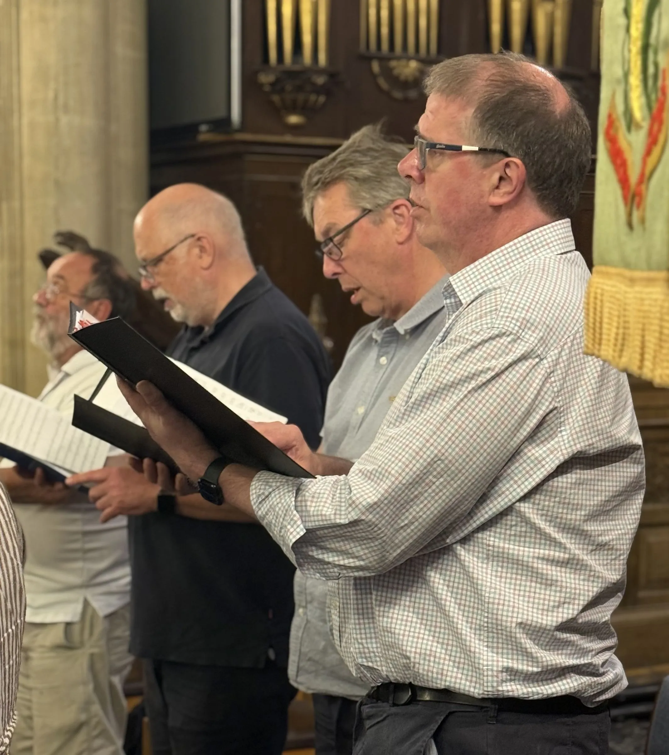 Basses standing and singing from their scores